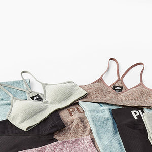 Flatlay of pursue fitness sports bras, tops and leggings