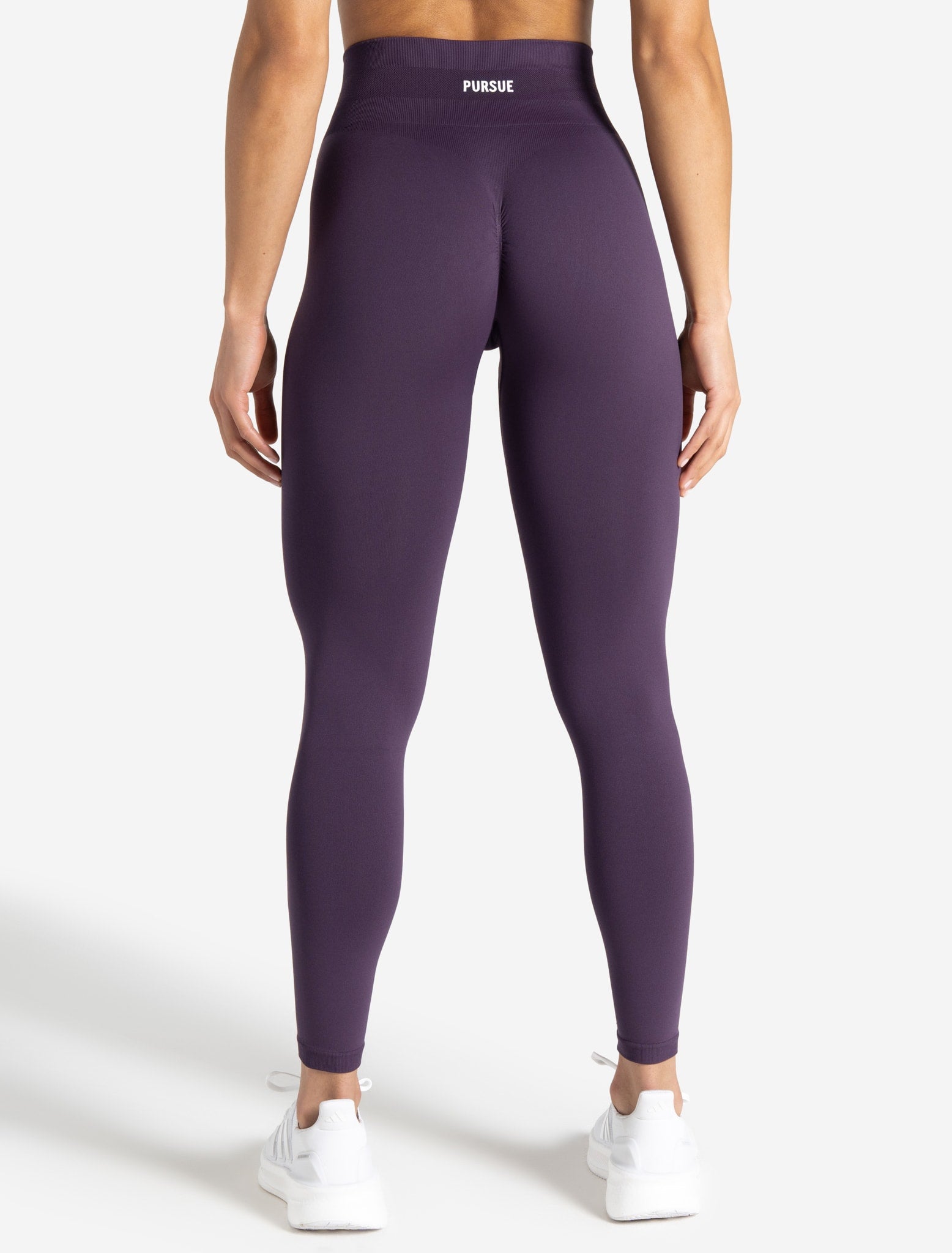 Purple leggings worn by a person on a white background
